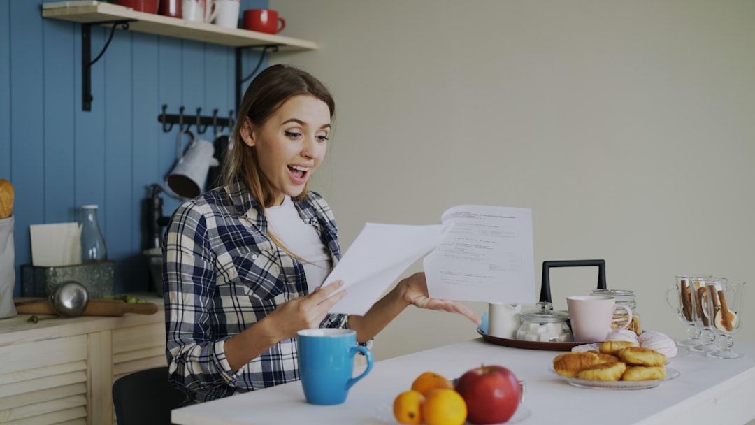 A new mother reviewing a structured postpartum care plan document at home, looking calm and supported