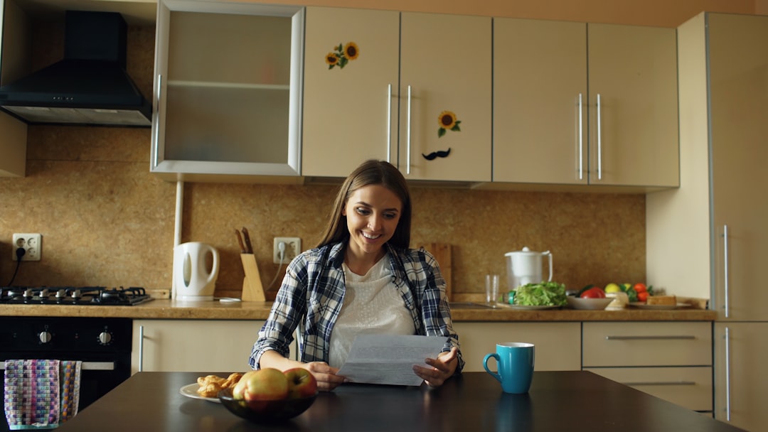 A mother sitting comfortably at home reviewing a postpartum care plan on a tablet, warm natural light, reassuring and real