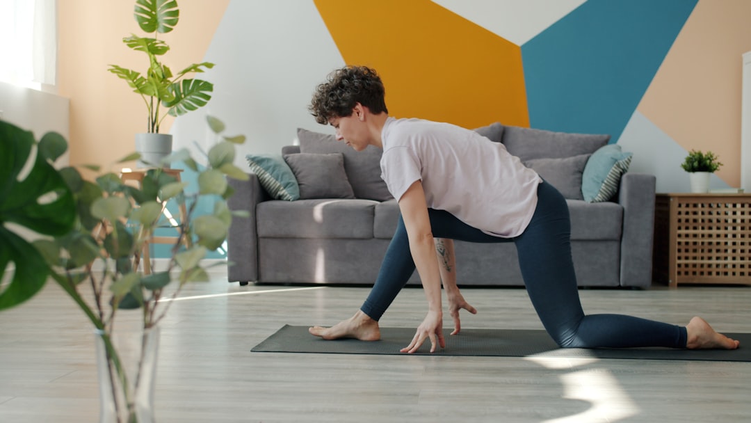 A postpartum woman doing gentle stretching exercises at home, moving carefully and with focus