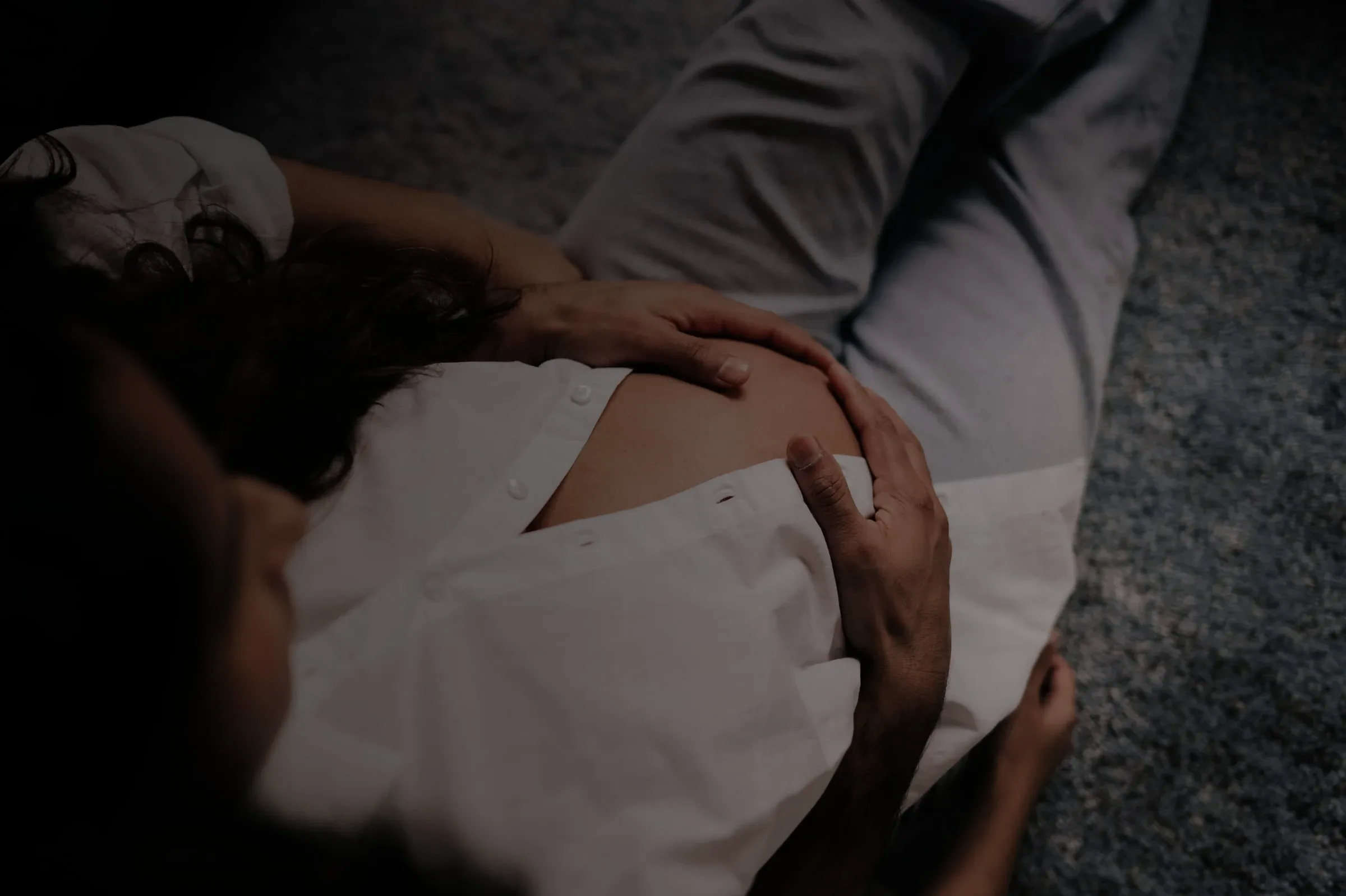 A joyful new mother cradling her newborn at home, looking calm and supported, warm natural light