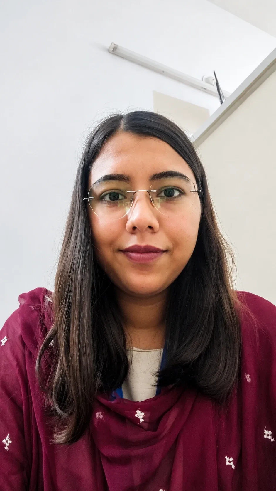 Shivani Kirar, a clinical psychologist in a warm professional setting, calm and approachable expression