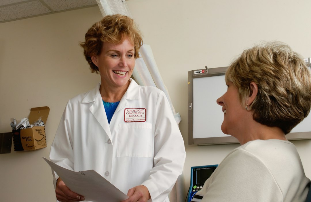 A practitioner reviewing a patient's temperature chart and case history across multiple visits, attentive and systematic