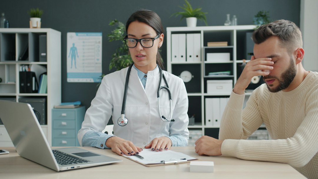 A woman in a thoughtful conversation with a homeopathic practitioner reviewing her health history, professional and attentive