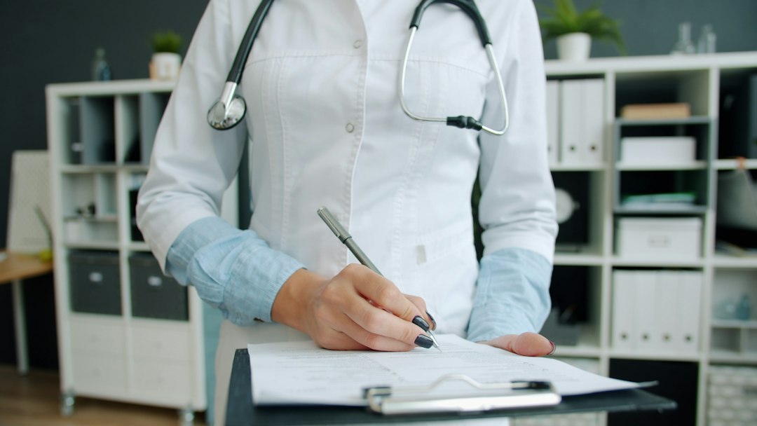 A doctor reviewing a patient's case notes and follow-up progress on a desk with a calendar and file, focused and methodical