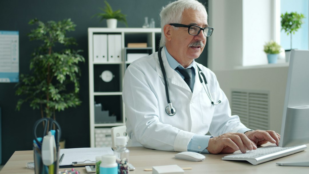 Patient seated across from a homeopathic doctor at a clinic desk during a detailed consultation