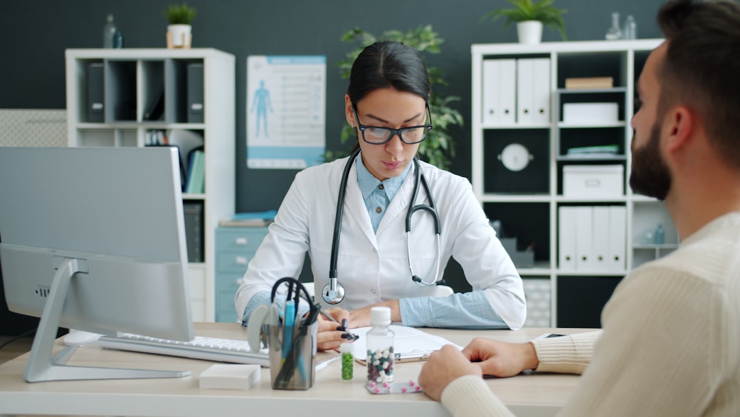 Patient seated across from a homeopathic doctor at a clinic desk during a detailed consultation