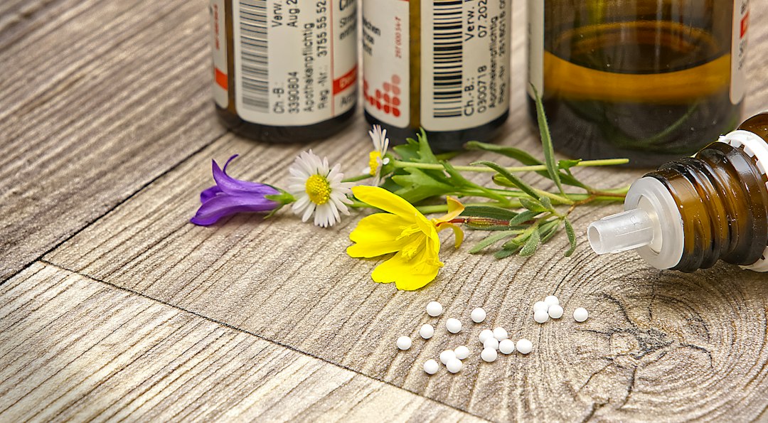 A neatly arranged set of small labeled homeopathic remedy vials and a printed case card on a wooden surface