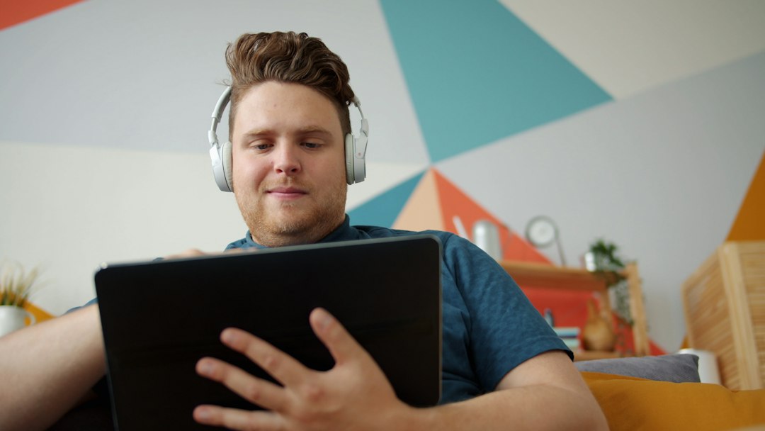 A person speaking with a doctor over a video call on a laptop at home, looking attentive and at ease
