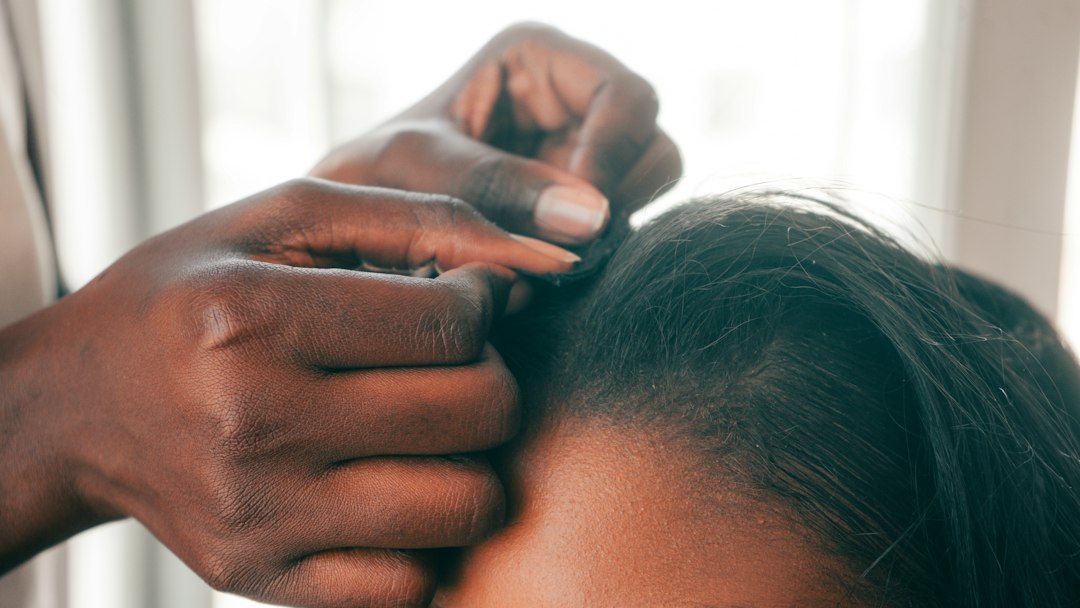 Person with thick healthy hair being examined at a trichology consultation, clinical yet warm setting